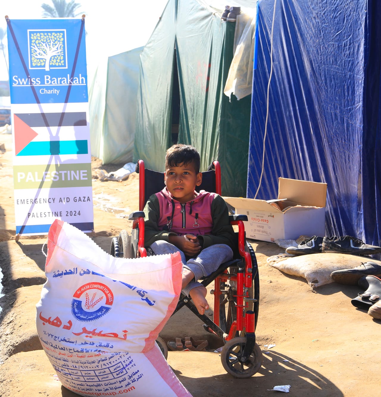 Distribution de la Zakat al‑Fitr à un enfant dans le besoin dans un camp de tentes à Gaza