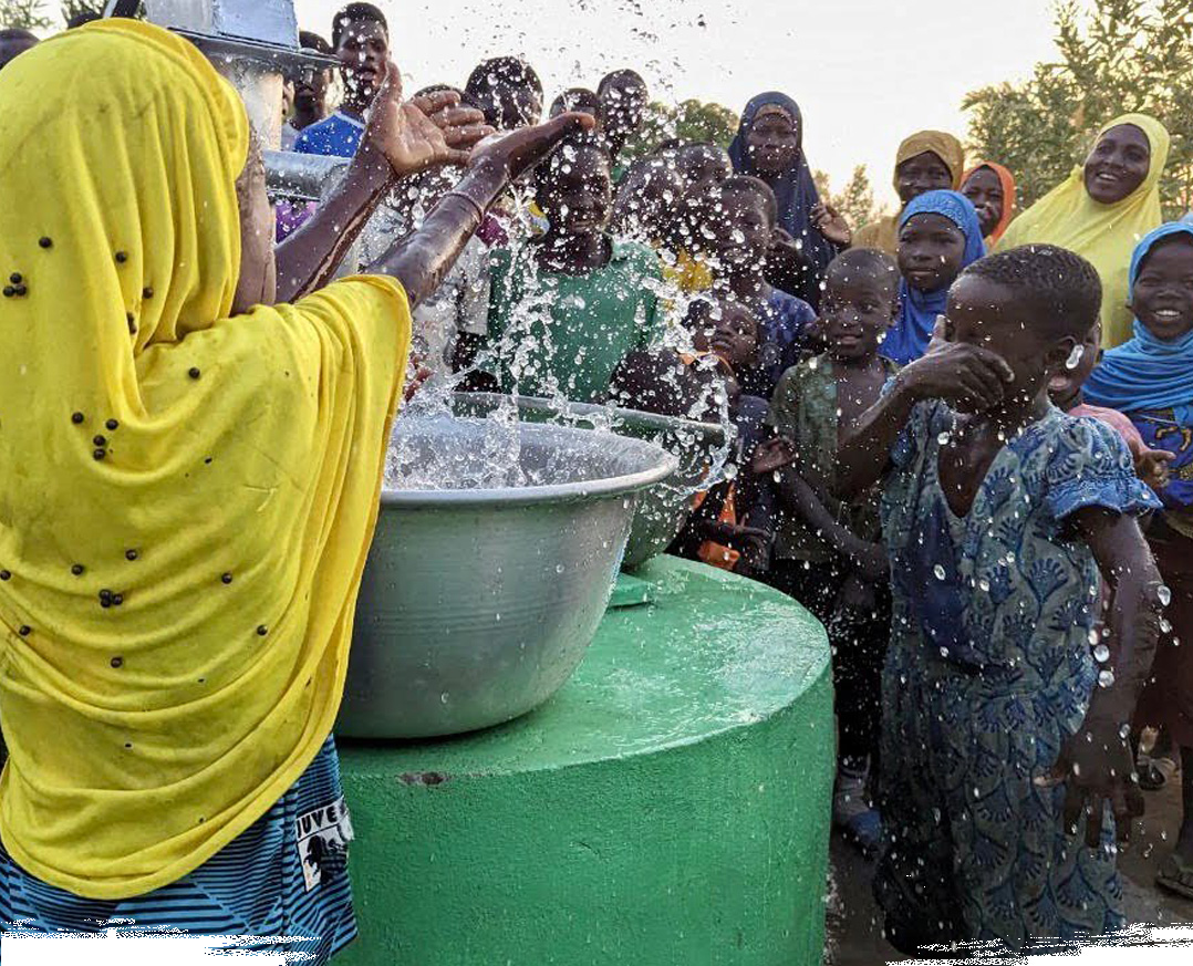 "Happy children splashing water from a Ramadan well in Africa"